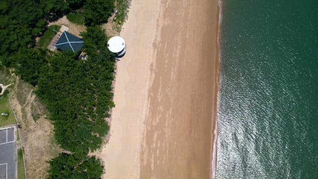 Beach with Clear Waves and Nearby Parking Lot