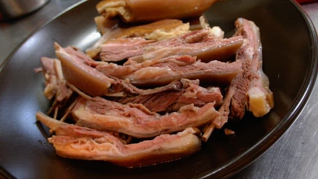 Delicious boiled meat dish neatly plated on a black plate