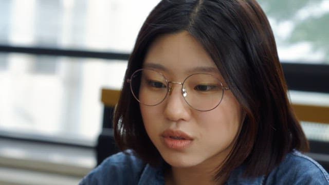 Woman wearing glasses in a discussion