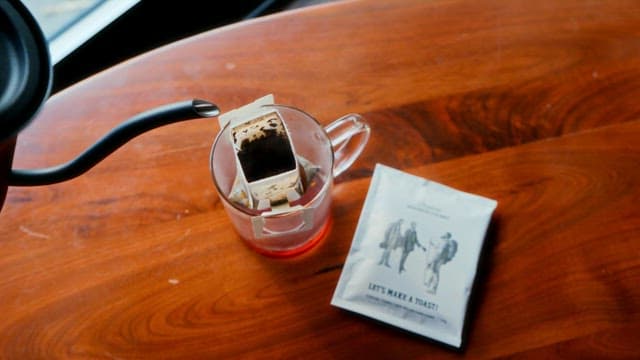 Pour Warm Water Over the Prepared Tea Bag on Wooden Table