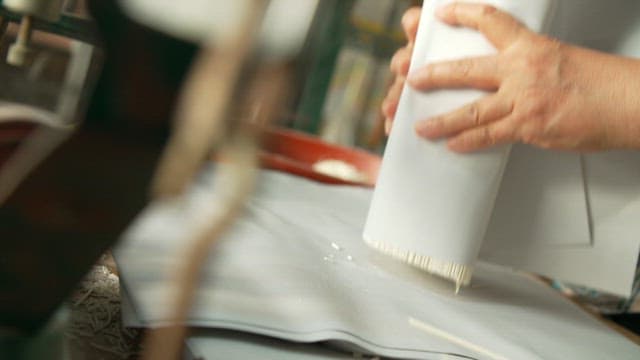 Hands carefully wrapping noodles on the workbench