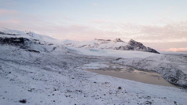 Snow-covered mountains and icy lake