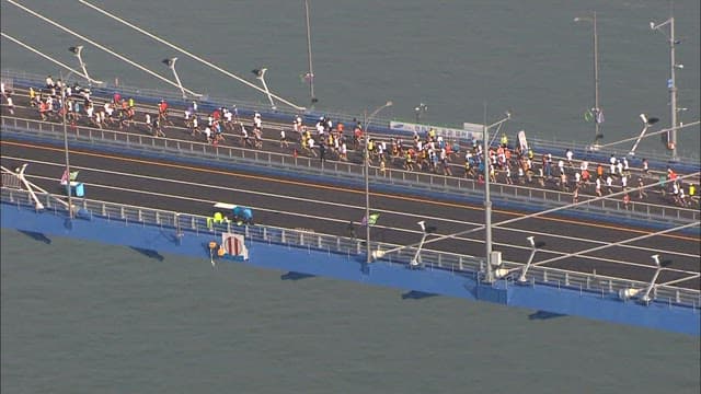 Marathon runners crossing a large Incheon bridge