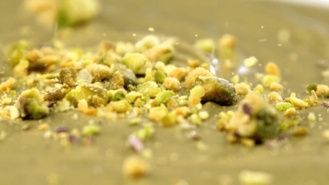 Crushed pistachio falling on thick surface