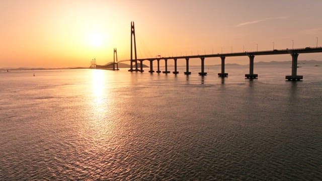 Bridge over calm waters at sunset