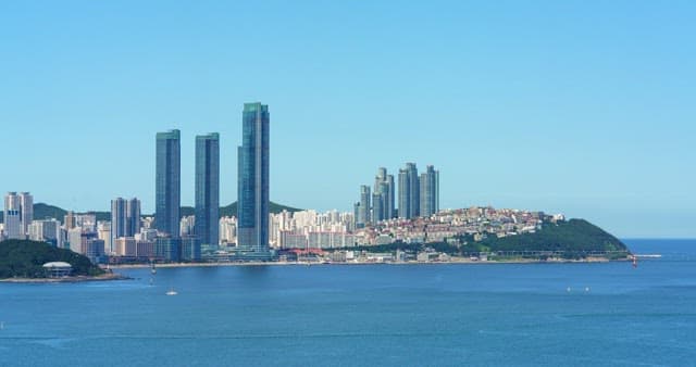Busan, a modern city with high-rise buildings and calm, blue sea