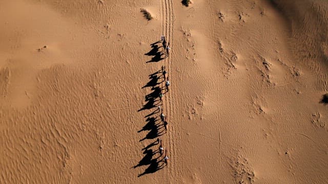 People riding camels in the desert