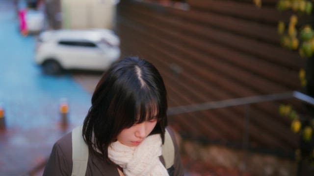 Student walking with earphones in winter