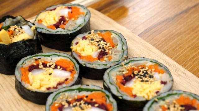 Kimbap neatly arranged on a wooden cutting board