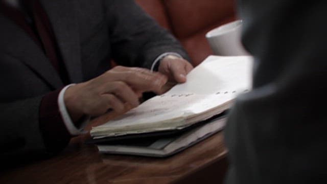 Person Sorting Through Papers on Desk