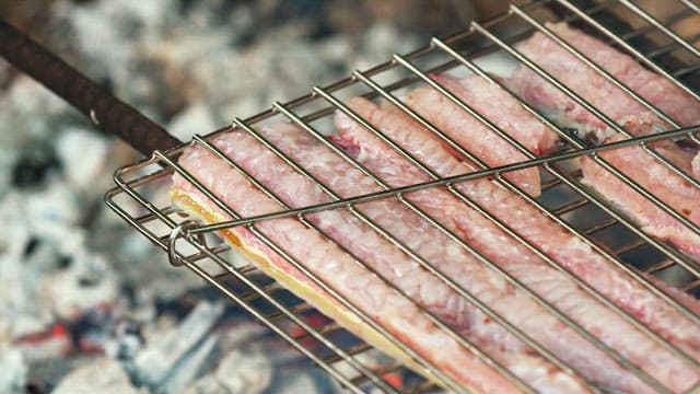 Eels grilling on a barbecue over coals