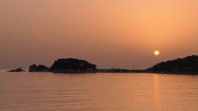 Red sky and calm coast colored by the evening glow
