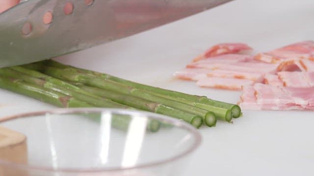 Cutting Fresh Asparagus on a Cutting Board