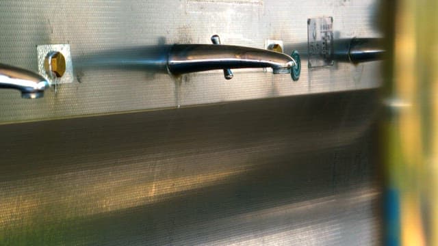 Pplastic container filled with water from a faucet at a sink