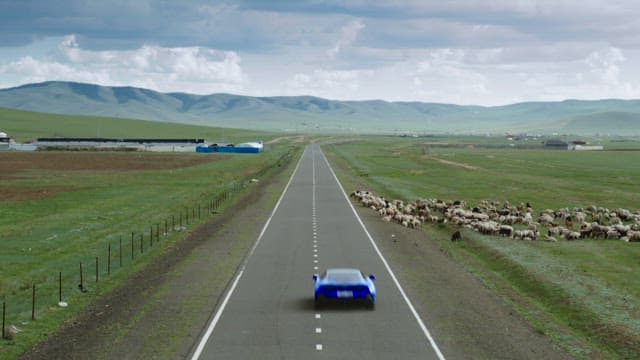 Blue car driving through rural landscape