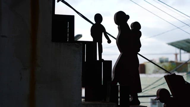Silhouette sculpture of a person holding a baby