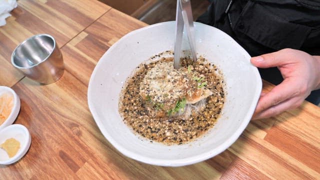 Bowl of cold noodle soup with sesame seeds garnish