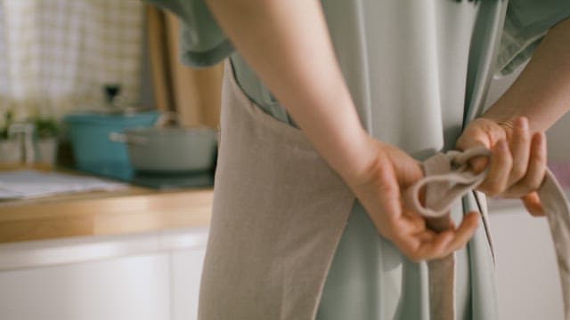 Tying an Apron in a Sunny Kitchen