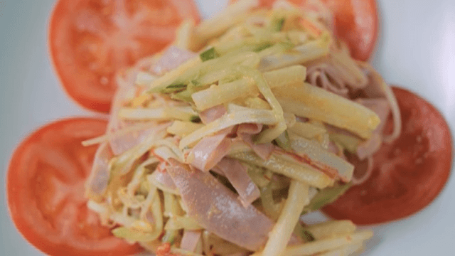 Lunch salad with sliced tomato on a white plate