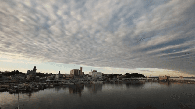 Coastal Village with Boat Anchored Under Cloudy Dusk Sky