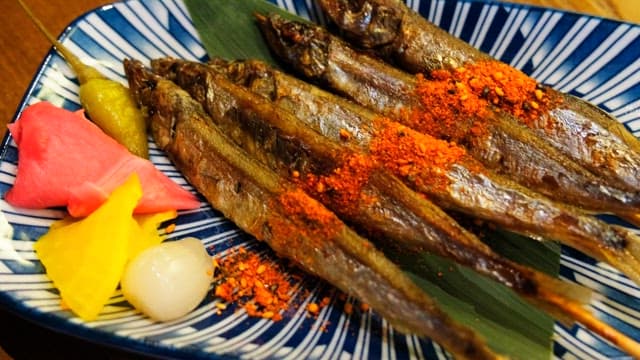 Grilled shisamo skewers neatly placed on a plate
