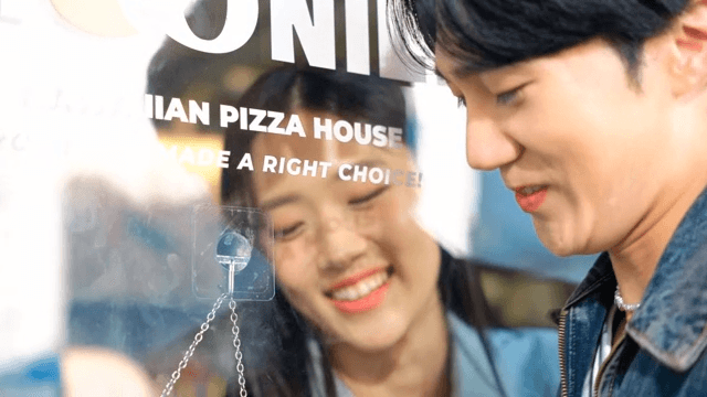 Couple playing around through a glass door