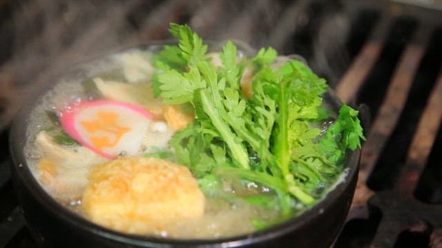 Udon noodles with fish cake boiling on the stove