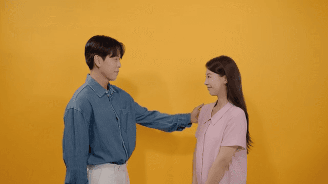 Man patting a woman on the shoulder and complimenting her