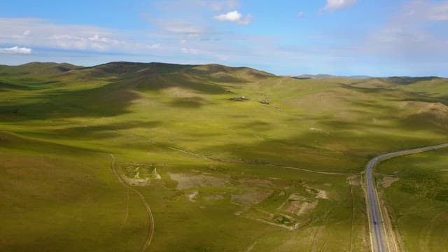 Vast green hills under a clear blue sky