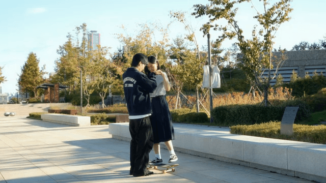 Couple learning to skateboard in a park