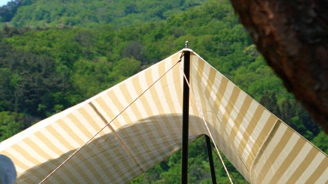 Outdoor camping with striped canvas tent in sunny forest