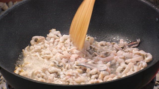 Cooking seafood in a frying pan with trimmed eel