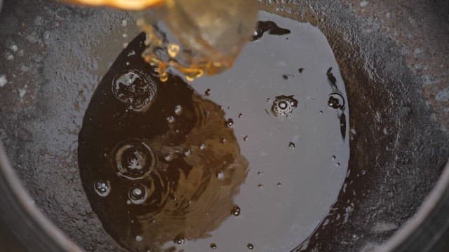 Brown soy sauce poured into a black container