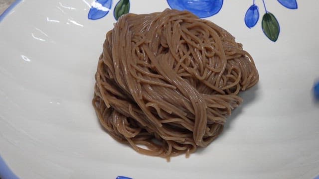 Close-up of noodles with pouring broth of cold noodle