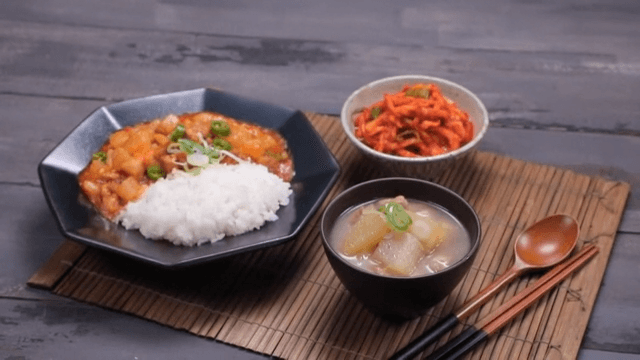 Table with julienne Korean radish salad, rice bowls, and soup