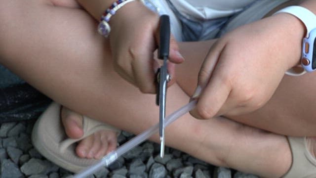 Child using a straw to blow air into a tube