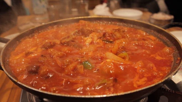 Simmering Pot of Spicy Stew on a Table in a Restaurant