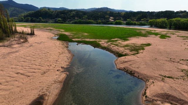 Serene river flowing through a sandy field