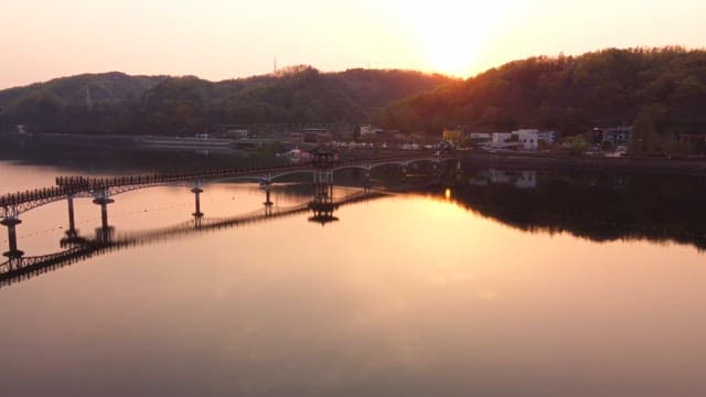 Serene river with a bridge at sunset