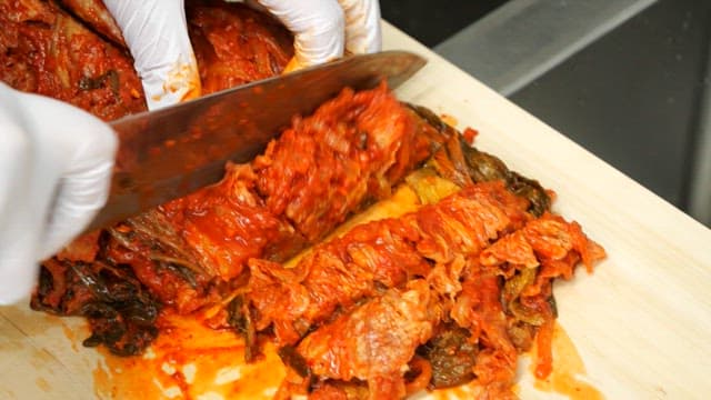 Stir-frying kimchi in a pan cut on a cutting board