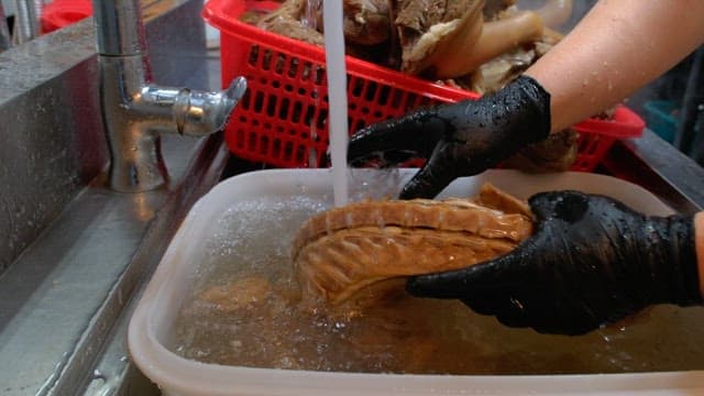 Rinsing boiled pig's feet and meat in water in the kitchen