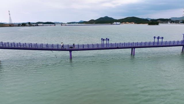 Purple bridge over a calm sea