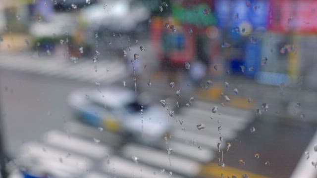 Raindrops on a window overlooking a city street