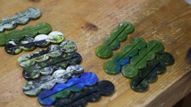 Tube squeezers of various colors made from recycled plastic on a wooden table