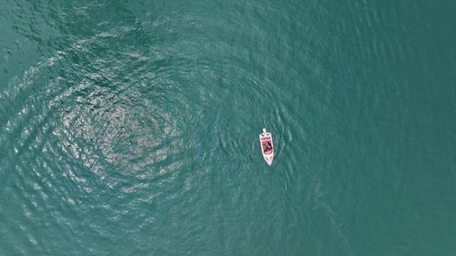 Small boat floating on a clear blue river