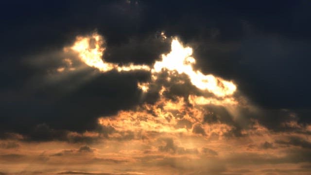 Sunlight breaking through dark clouds