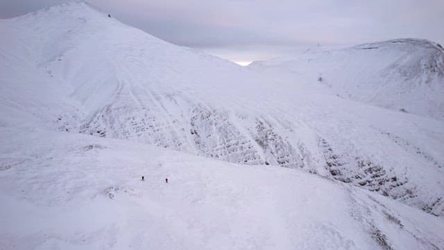 Snow-covered mountains with hikers