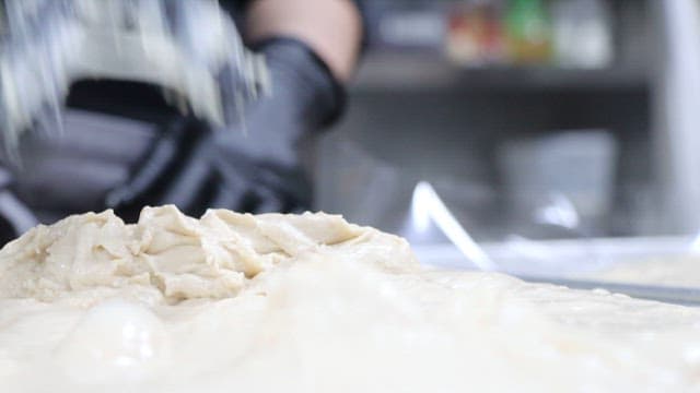 Person kneads dough in a kitchen