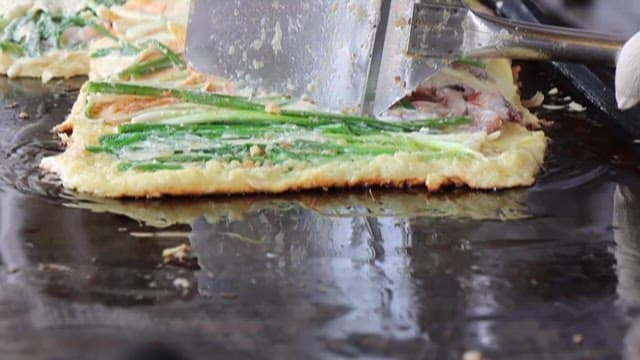 Seafood and green onion pancakes on a griddle