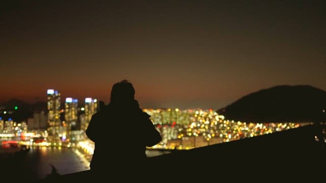 Person looking down on a city glowing with lights at night